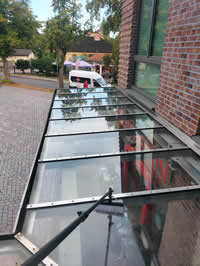 Gründliche Glasdachreinigung mit Teleskopbürste – Herdegen Gebäudeservice GmbH sorgt für klare Sicht und saubere Überdachungen.