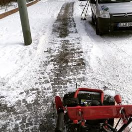 Geräumter Gehweg im Winter nach Schneeräumung mit Schneefräse: Gehwege und Zufahrten werden gründlich von Schnee befreit und mit Splitt oder Sand gestreut – für Sicherheit bei Eis und Frost